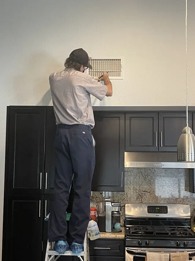 Technician inspecting an air vent during HVAC service in Nashville